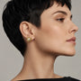 Model wearing gold-tone freshwater pearl sculpted flower stud earrings