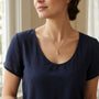Model wearing gold-tone filigree pearl drop pendant necklace