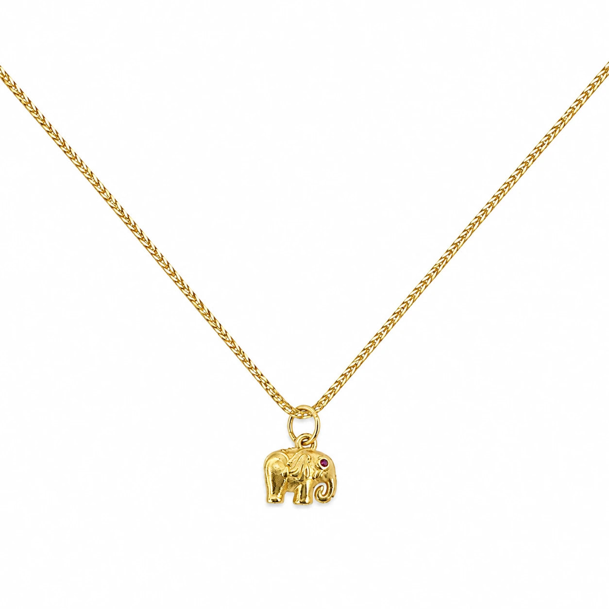 Gold-tone elephant pendant necklace with an upturned trunk and red stone accent
