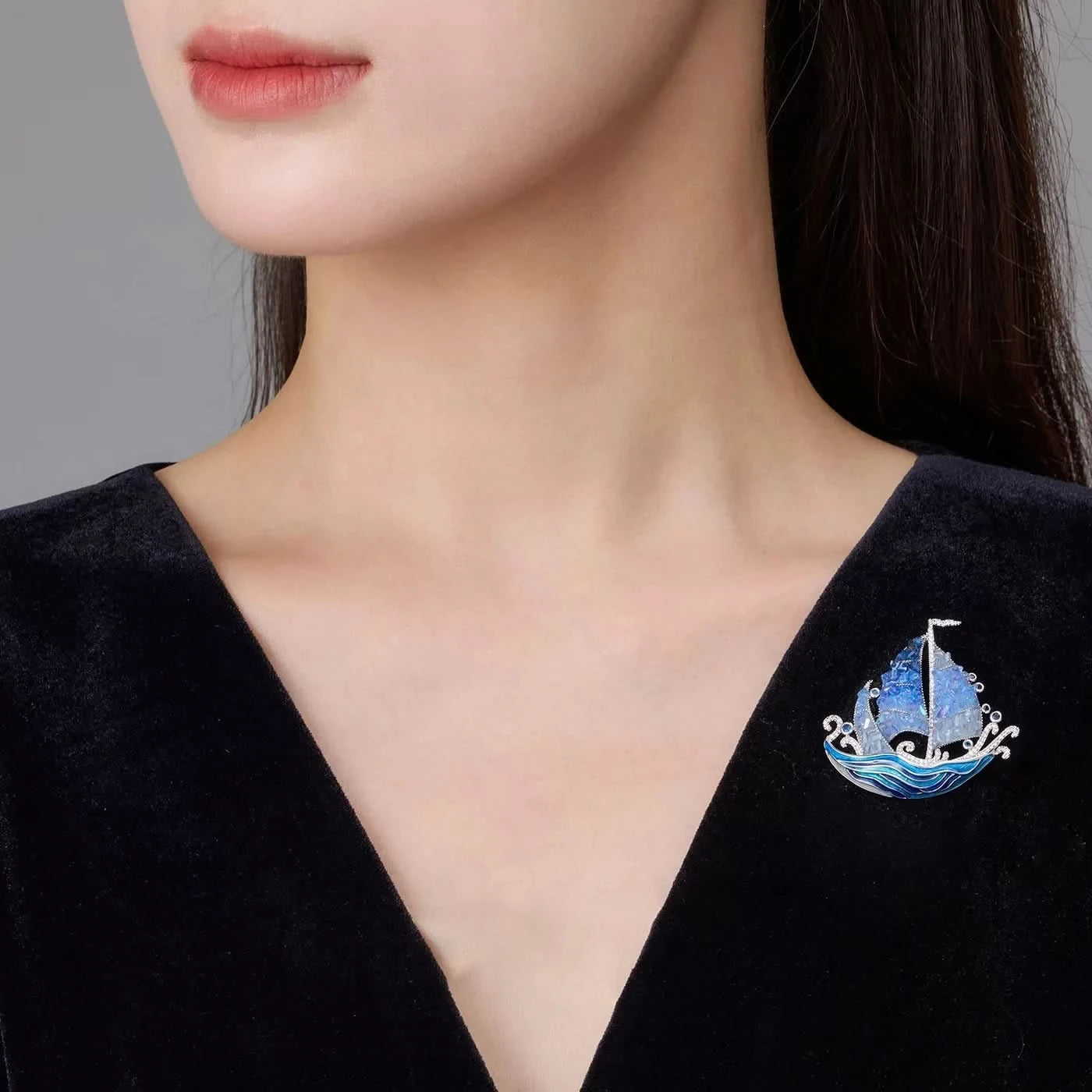 Blue crystal sailing ship brooch worn on a black velvet dress neckline