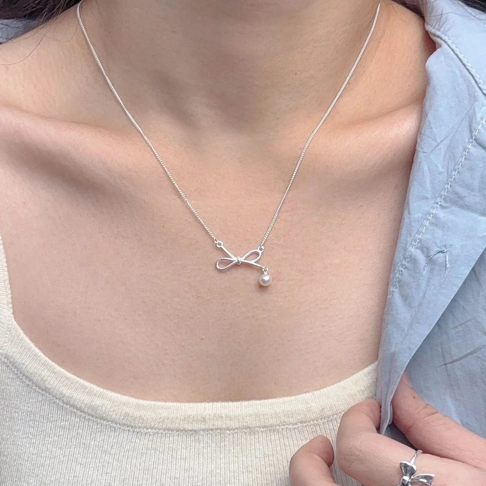 Silver necklace with a bow and pearl pendant 