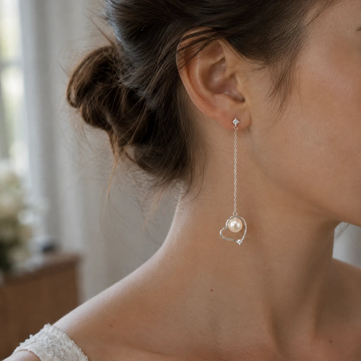 Model wearing silver heart pearl drop earrings