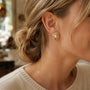 Model wearing gold-tone hammered organic freshwater pearl stud earrings