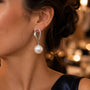 Model wearing silver sculpted pearl drop earrings