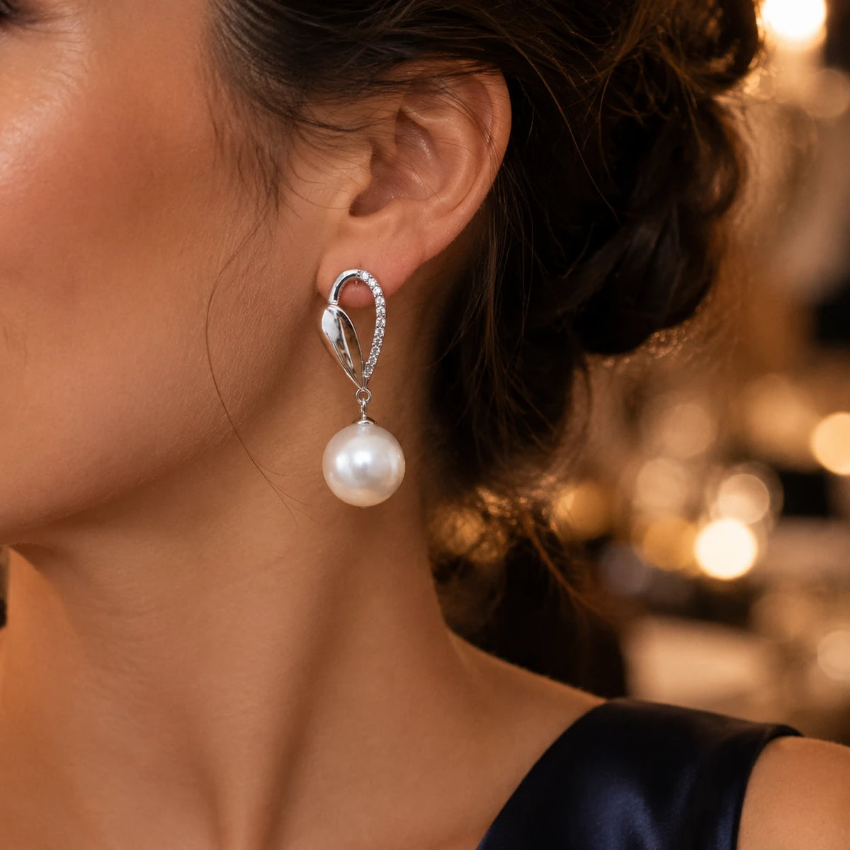 Model wearing silver sculpted pearl drop earrings