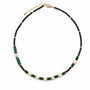 Malachite-style black crystal and baroque pearl beaded necklace on a white background