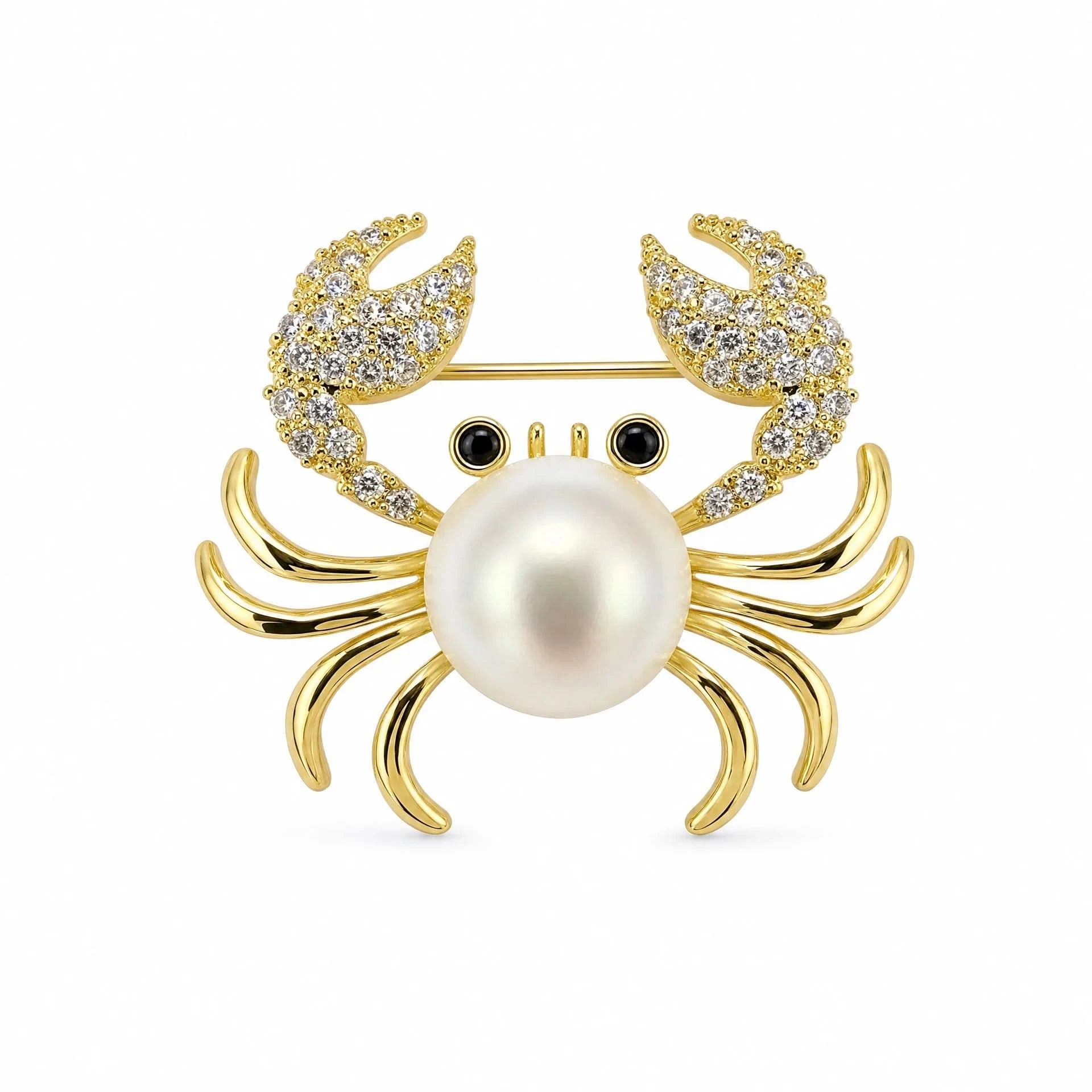 Gold-tone pearl crab brooch with cubic zirconia claws and black eyes on a white background