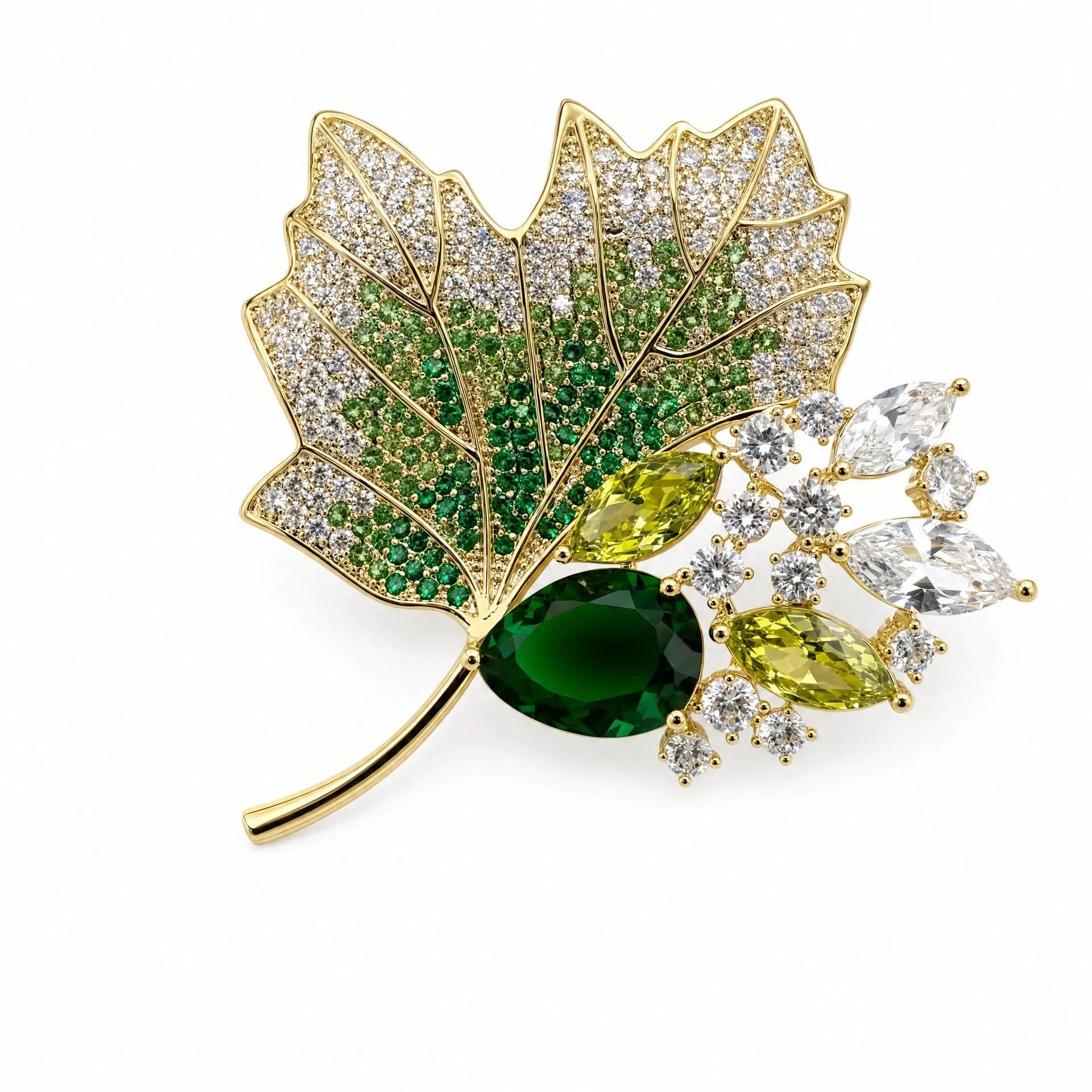 Gold-tone maple leaf brooch with clear and emerald-green crystals on a white background