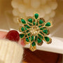 Back of gold-tone emerald-green crystal layered flower brooch with secure pin fastening